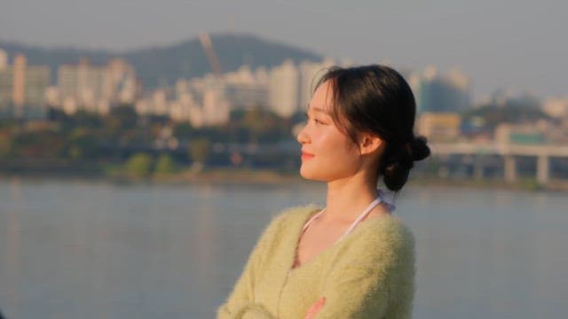 강가에서 사진을 찍기 위해 포즈를 취하는 여자