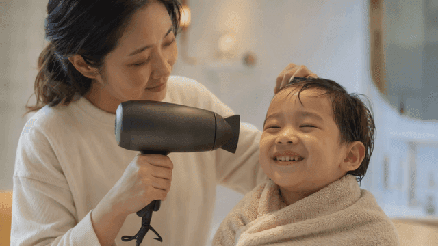 Mother drying her child's hair with a smile