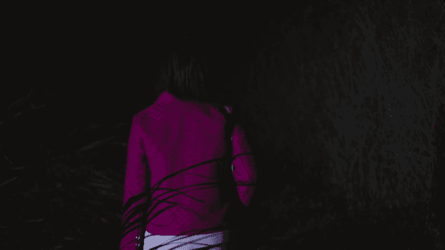 Back of woman walking alone at night