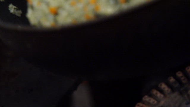 프라이팬에서 게 내장과 다진 채소로 만드는 볶음밥