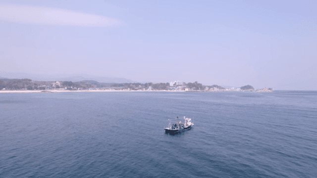 해안 마을 근처를 항해하는 배