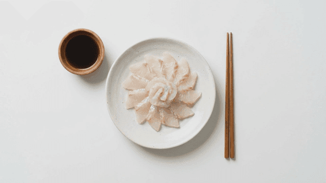 Sashimi arranged on a plate with soy sauce