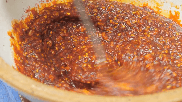 그릇에서 숟가락으로 소스를 섞는 장면