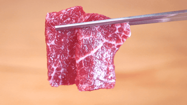 Korean beef chunk plate held with chopsticks