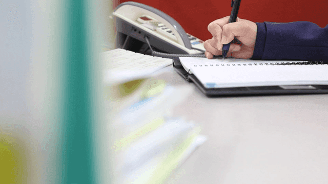 Person writing notes at a desk