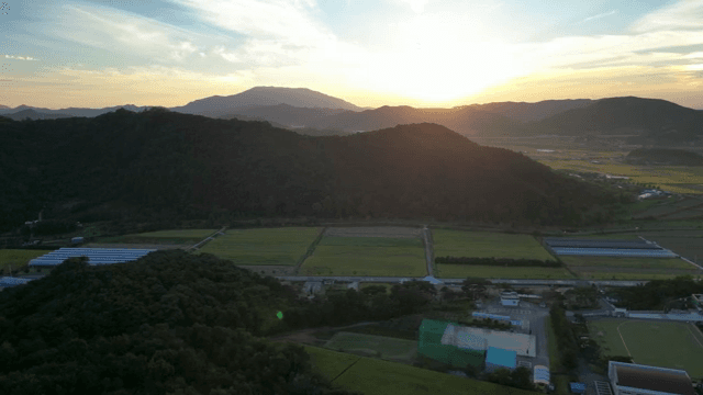 산과 농지를 비추는 일몰