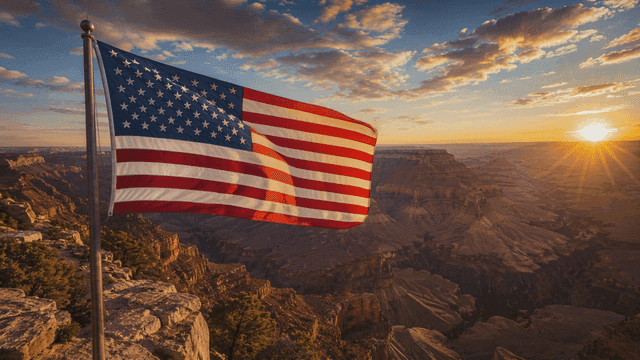 American flag waving at sunrise over canyon