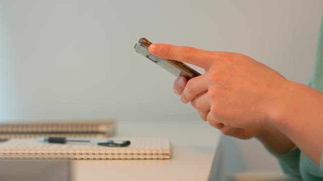 Person using smartphone at a desk