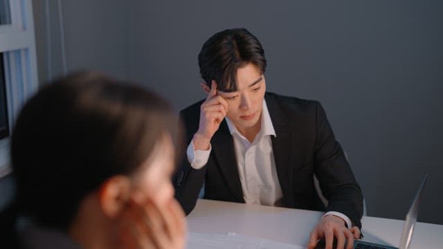 Two colleagues discussing work at a desk