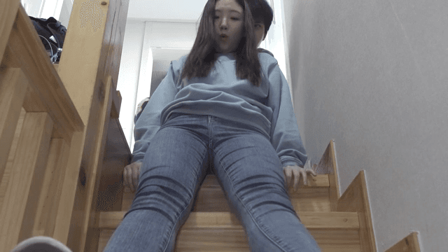 계단을 앉아 내려가는 여성 뒤로 장난치는 남성