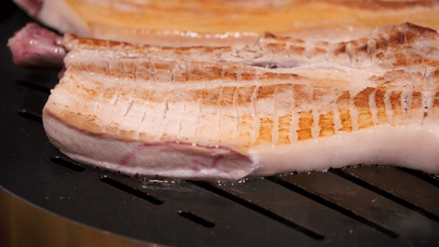 Grilling pork belly on a hot grill
