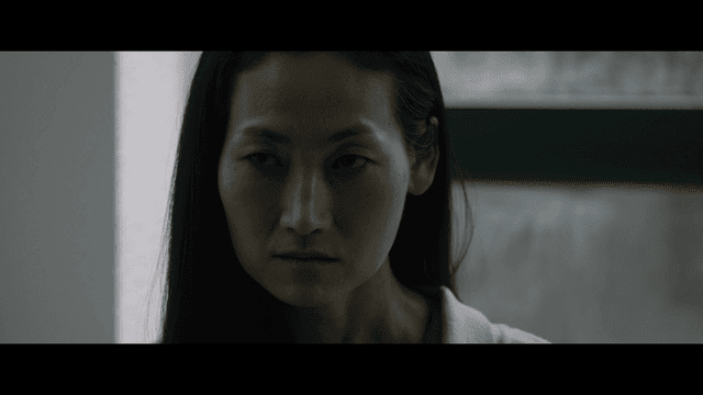 Woman with a serious expression indoors