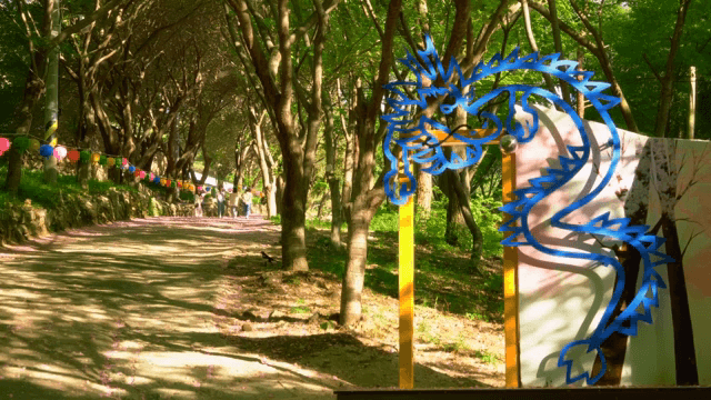 Dragon decoration on a forest path with colorful lanterns