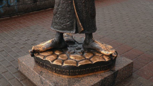 강변 산책로에 우산을 든 안톤 체홉의 청동 조각상