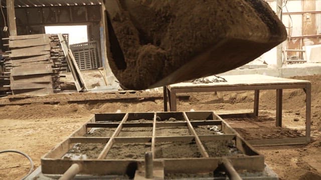 Sand being poured into a mold in a factory
