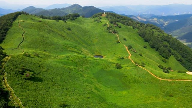 Lush green mountains with a small lake