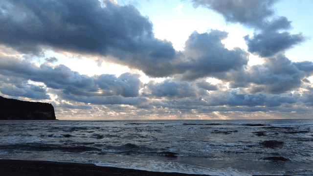 Tranquil beach sunset with waves and clouds