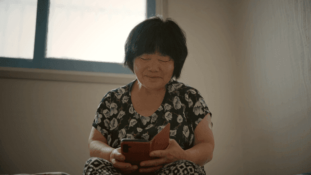 An elderly woman using a smartphone indoors