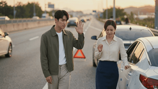 Two people talking on shoulder of highway