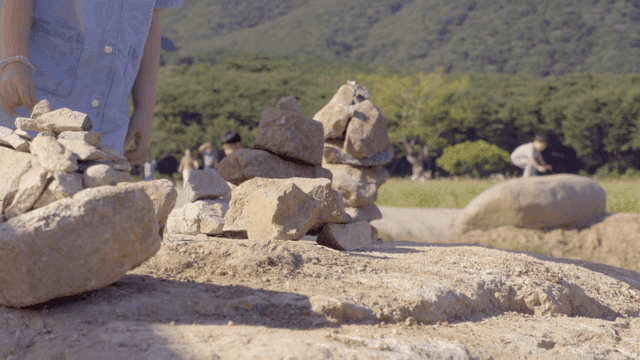 들판에서 돌을 쌓는 아이