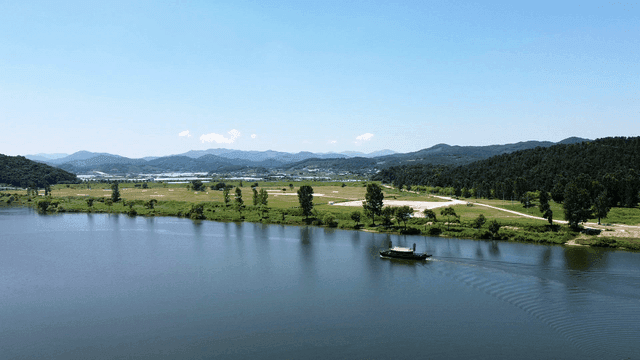 Tranquil river and distant mountains with traditional Joseon Panokseon ships