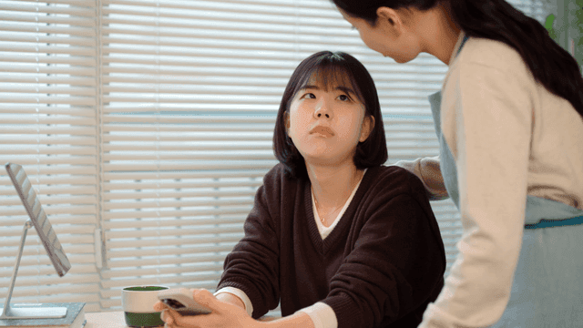 Mother comforts her frustrated daughter who is looking at her phone.