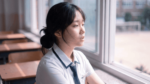 교실 창밖을 바라보며 한숨 쉬는 여학생