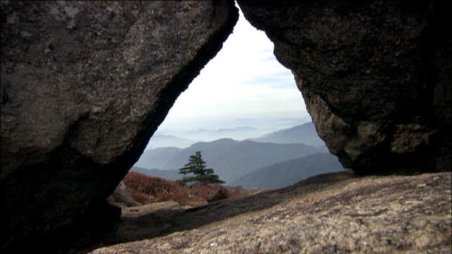 Misty Mountain Range Through Rock Formation