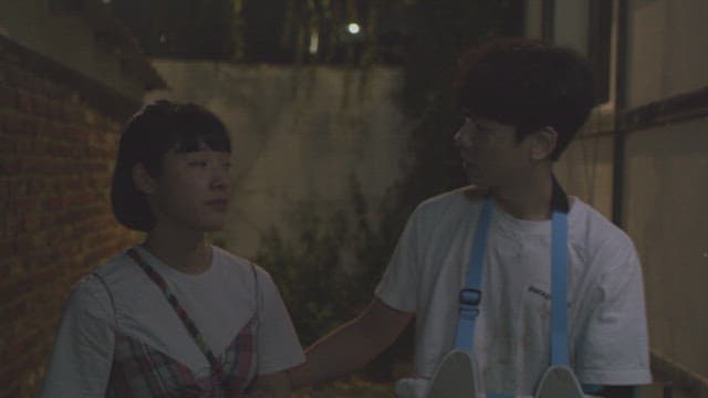 밤의 골목을 걷는 팔에 깁스를 한 남자와 여자