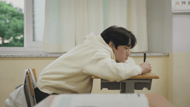 교실에서 책상에 엎드려 공부하는 학생