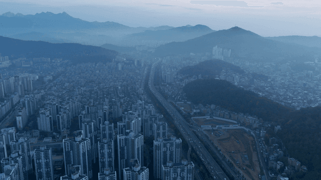 멀리 산이 보이는 새벽 도시 전경