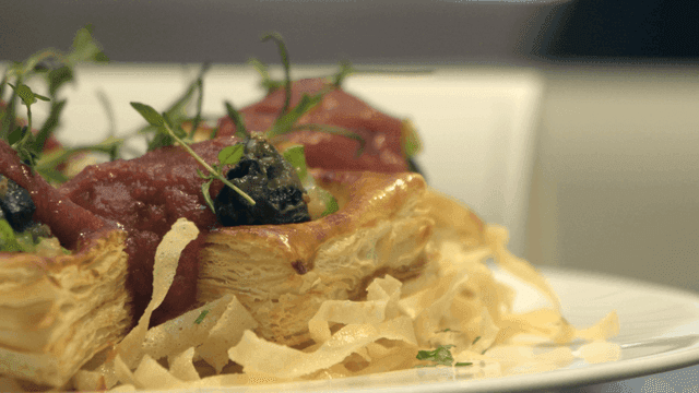 Gourmet dish with pastry and garnish