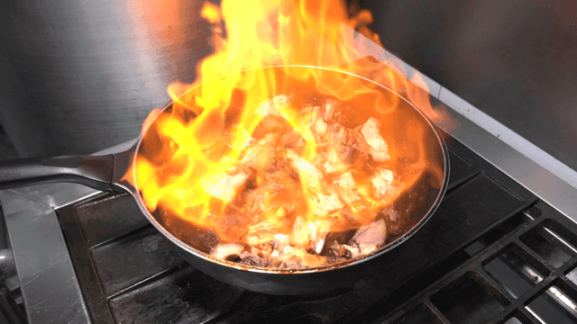 Pig's trotters grilled over flames in pan