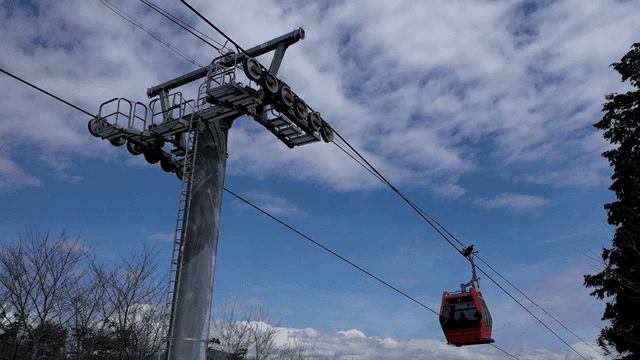Red cable car crossing sky