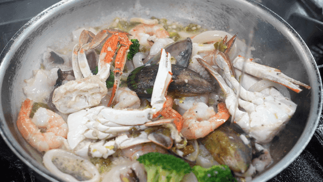 Variety of seafood cooking in a pan