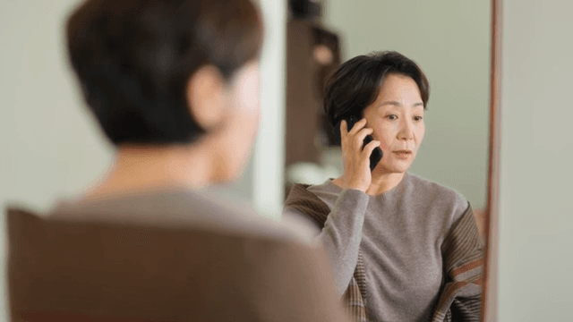 거울을 보며 전화하는 여성