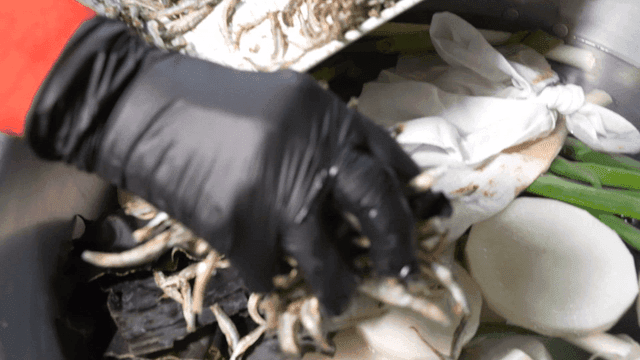 Dried fish being poured into broth pot