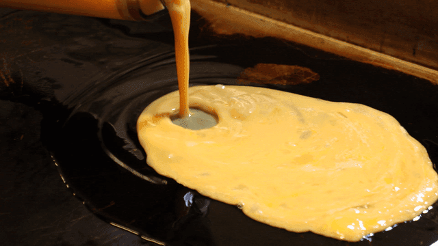 Egg mixture poured onto hot iron plate
