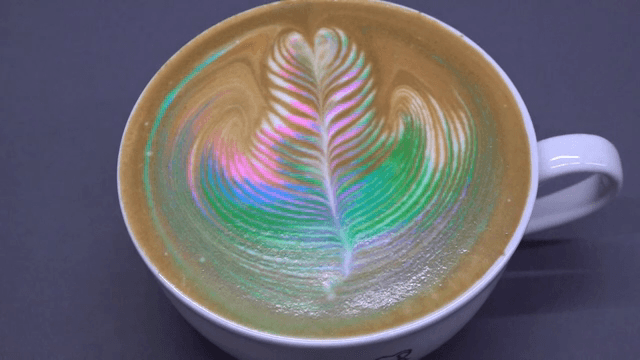 A cup of coffee with rainbow latte art