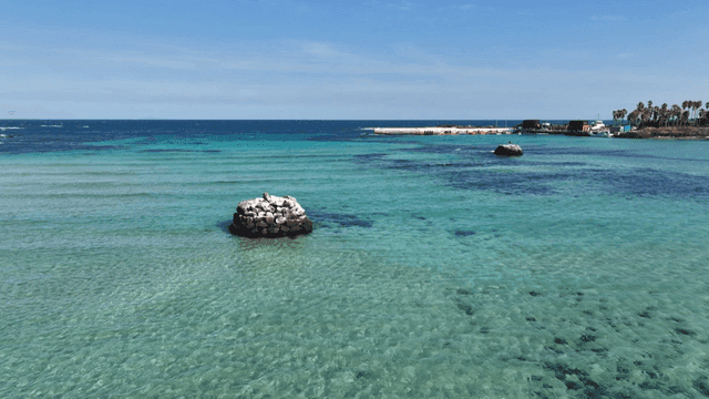 Clear turquoise sea with distant pier