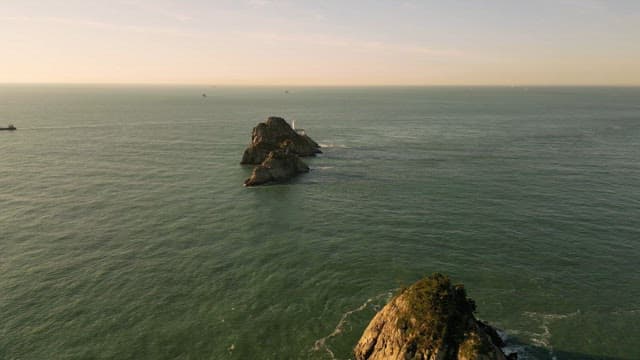 잔잔한 바다에 둘러싸인 바위섬