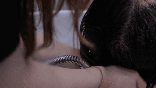 Hairdresser washing hair at beauty salon
