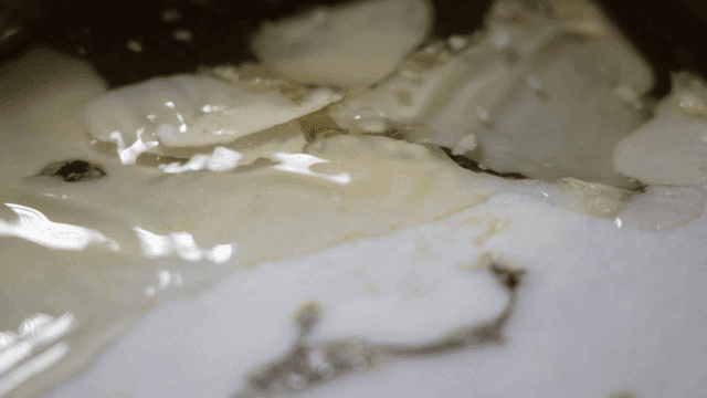 Thin layer of oil swaying on top of broth