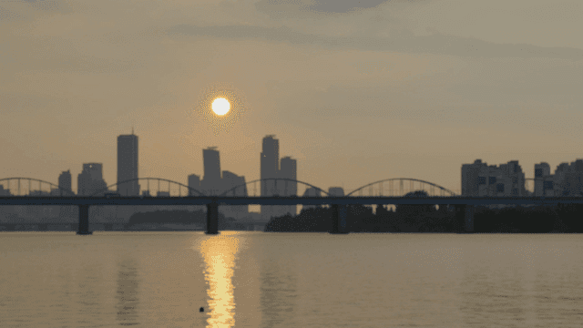 Sunset over a city skyline with a bridge