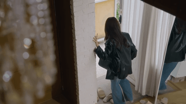 급하게 신발을 신고 문 밖을 나서는 여성