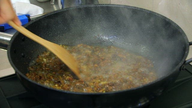 기름에 대파를 튀기고 고춧가루로 양념하는 모습