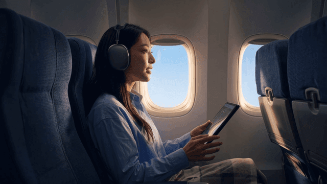 Woman enjoying tablet on airplane