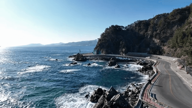 파도가 바위에 부딪히는 해안 도로