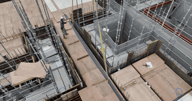 크레인 하중을 안내하는 건설 작업자들