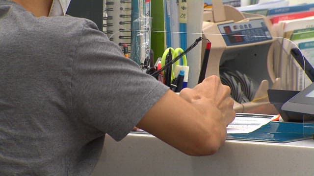 은행에서 한국 화폐 5만원 뭉치의 돈을 다루는 사람